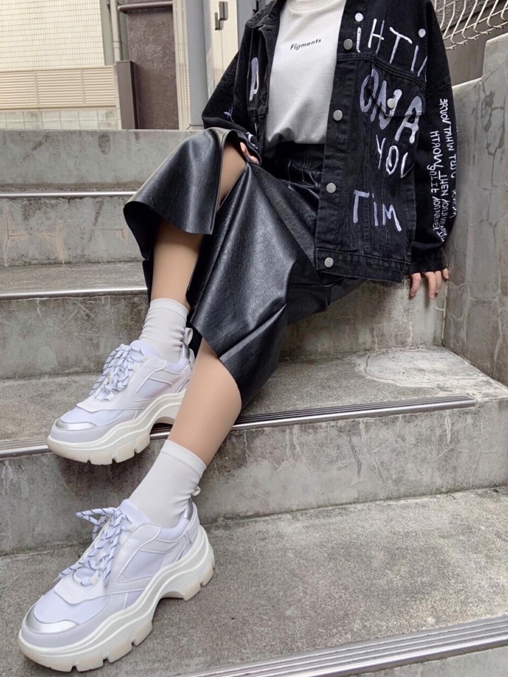 ブラック系のデニムジャケット、ホワイト系のTシャツ/カットソー、ブラック系のスカートを着用したレディースの冬コーディネートの1枚目の写真