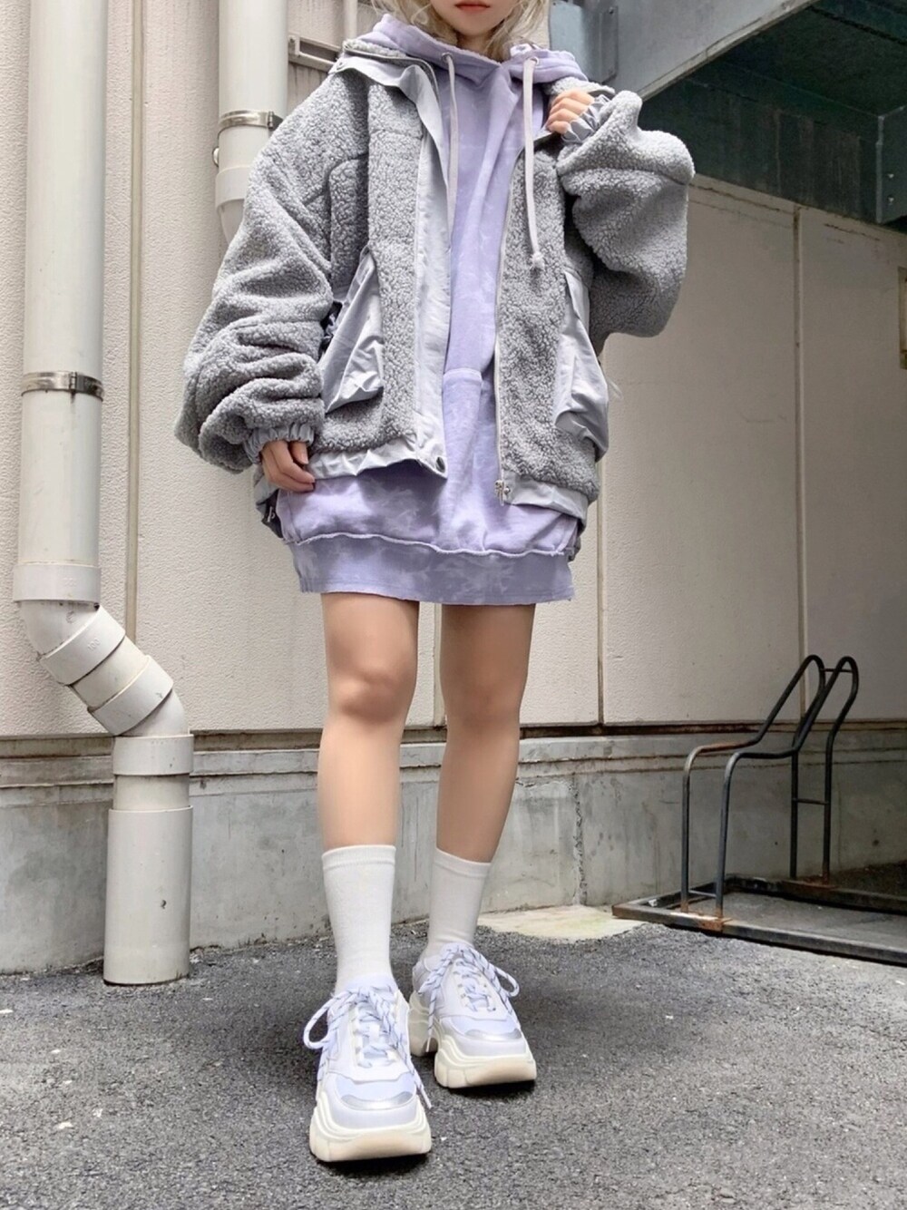 グレー系のパーカー、ホワイト系のスニーカー、グレー系のブルゾンを着用したレディースの冬コーディネートの1枚目の写真