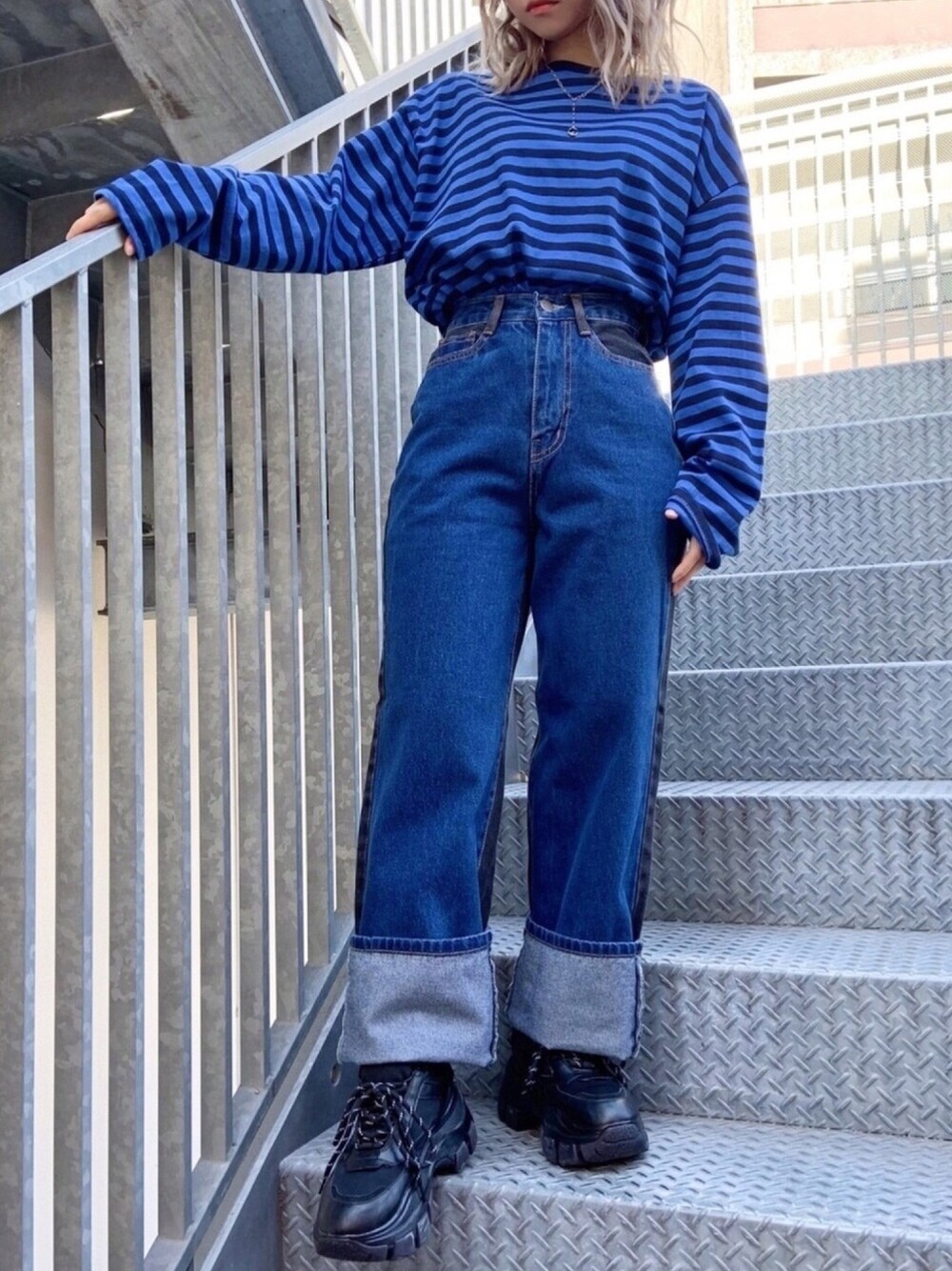 ブルー系のTシャツ/カットソー、ブラック系のスニーカー、ブルー系のデニムパンツを着用したレディースの冬コーディネートの1枚目の写真