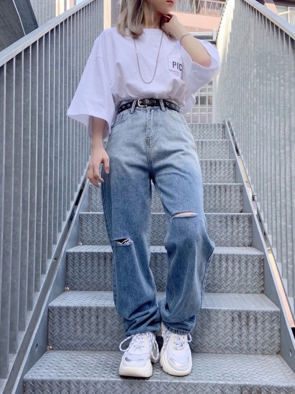 ホワイト系のスニーカー、ブルー系のデニムパンツ、ホワイト系のTシャツ/カットソーを着用したレディースの春コーディネートの1枚目の写真