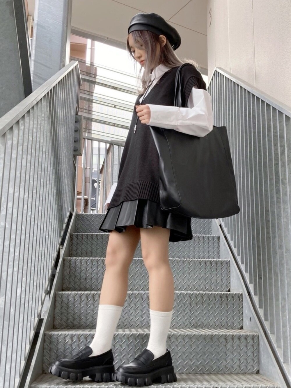 ブラック系のベスト、ホワイト系のシャツ/ブラウス、ブラック系のトートバッグを着用したレディースの春コーディネートの1枚目の写真