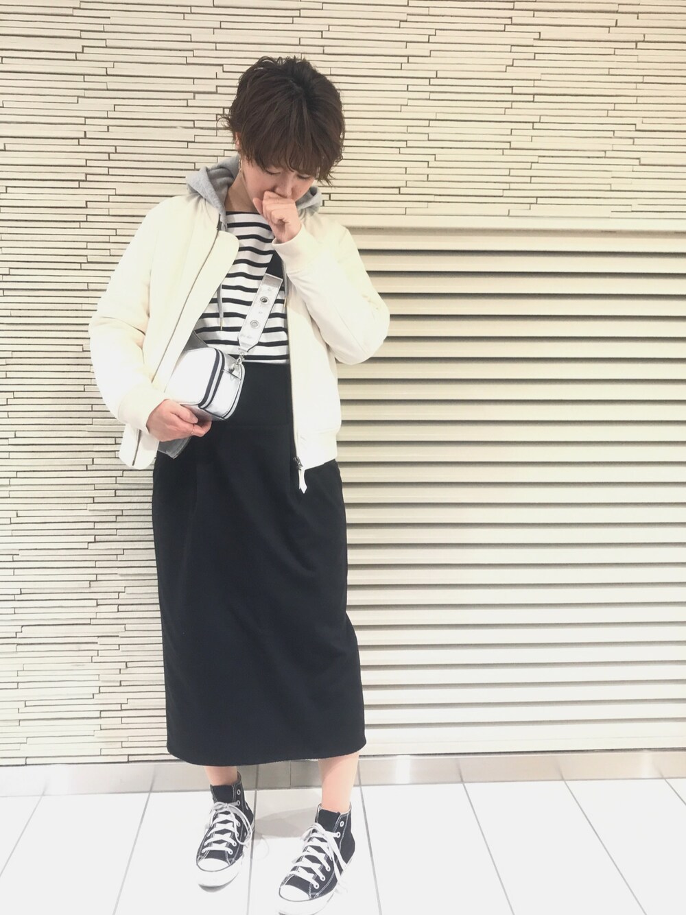 ブラック系のスカート、ホワイト系のMA-1、シルバー系のバッグを着用したレディースの春コーディネートの1枚目の写真