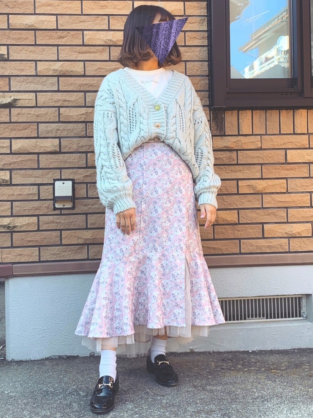 パープル系のスカート、グリーン系のカーディガン/ボレロ、ホワイト系のTシャツ/カットソーを着用したレディースの冬コーディネートの1枚目の写真