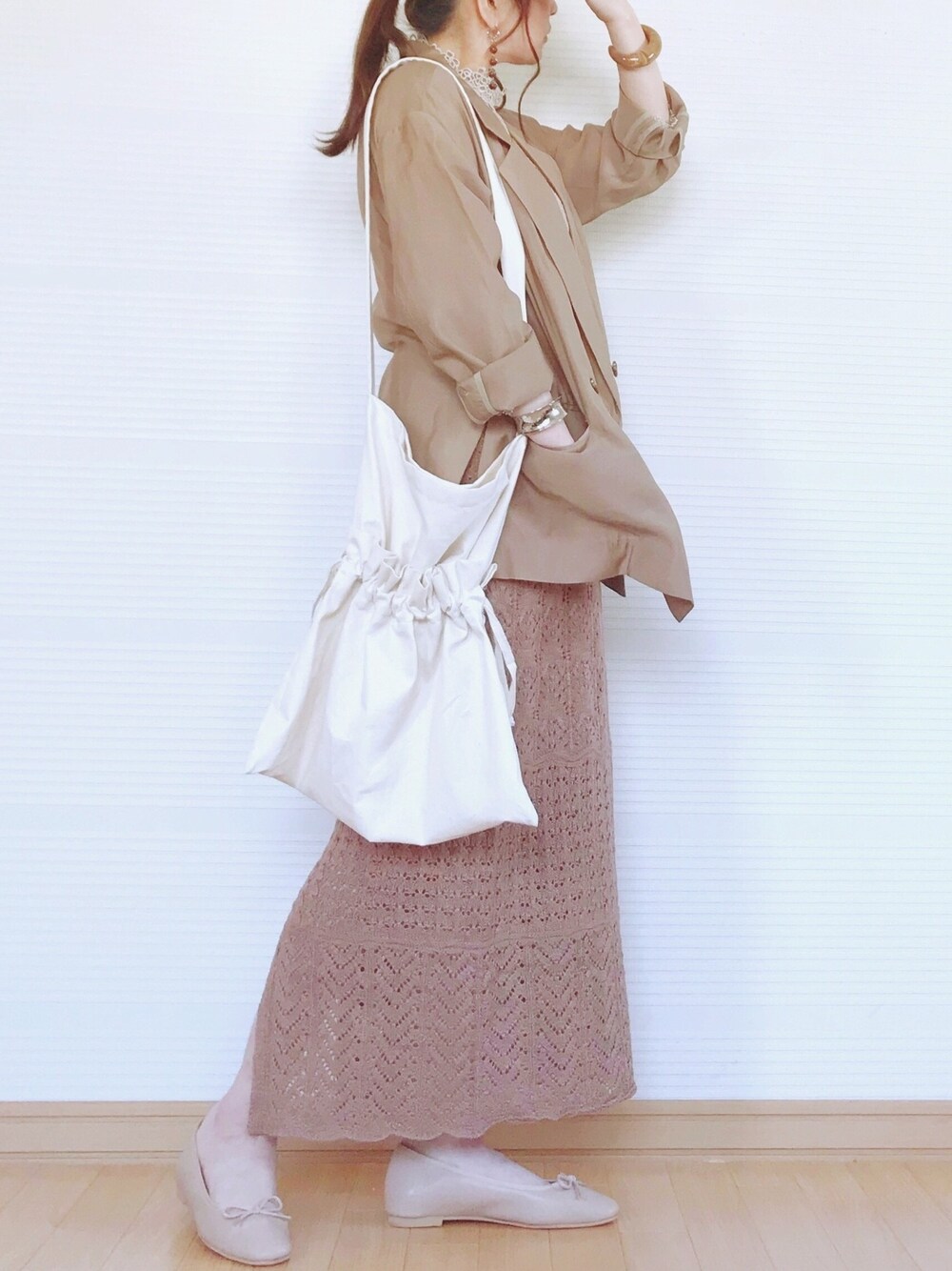 ゴールド系のシャツ/ブラウス、ベージュ系のテーラードジャケット、ブラウン系のスカートを着用したレディースの春コーディネートの1枚目の写真