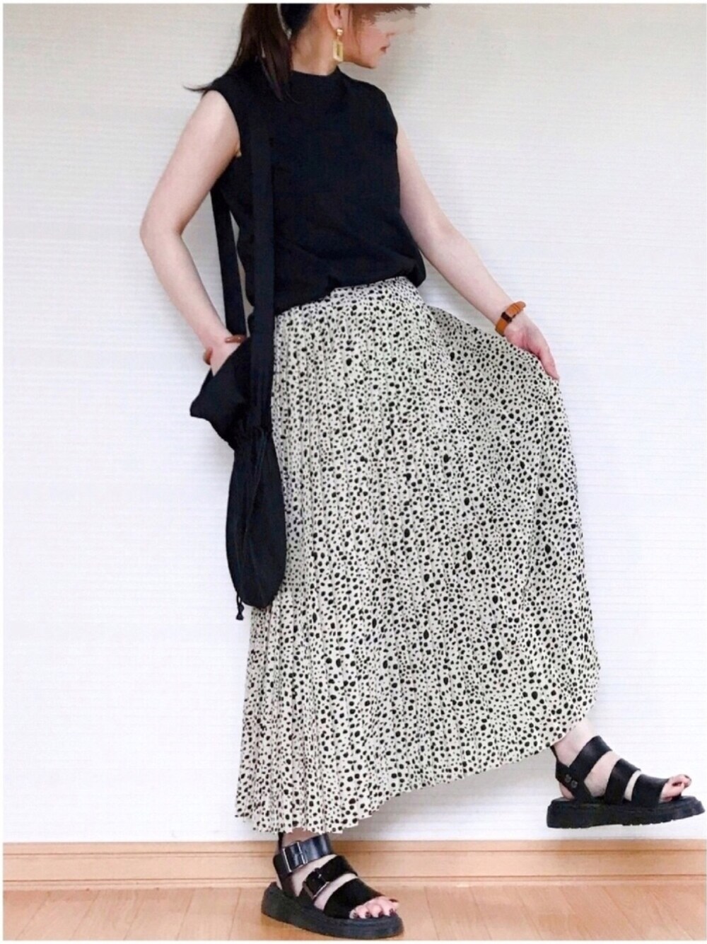ブラック系のTシャツ/カットソー、ホワイト系のスカート、ブラック系のサンダルを着用したレディースの夏コーディネートの1枚目の写真
