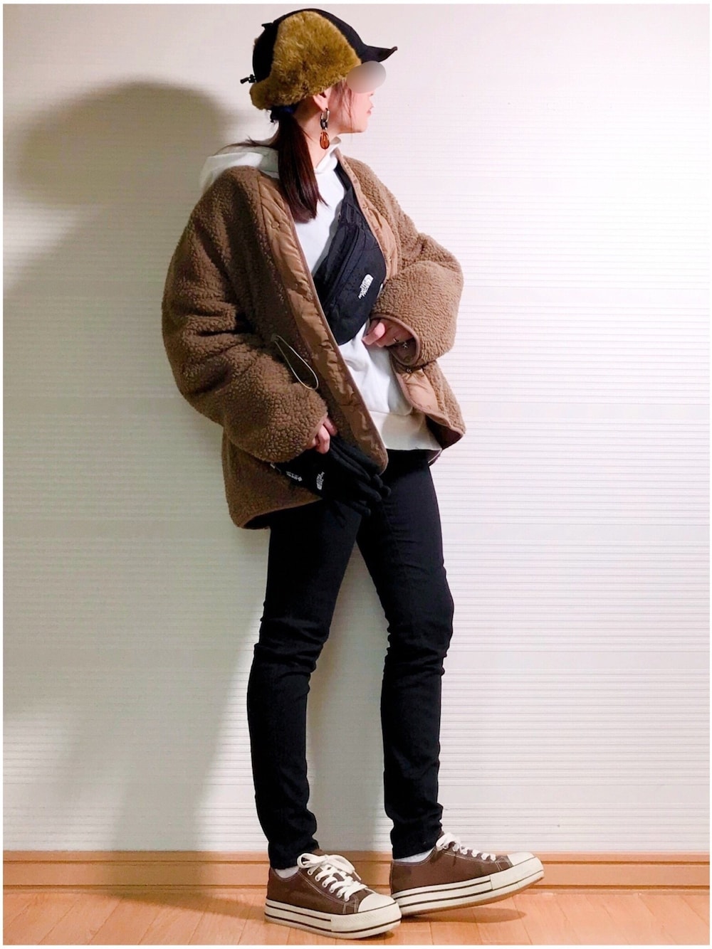 ホワイト系のパーカー、ブラウン系のブルゾン、ブラック系のボディバッグ/ウエストポーチを着用したレディースの冬コーディネートの1枚目の写真