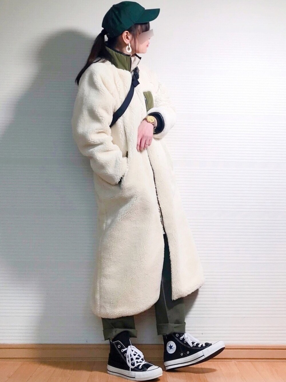 ホワイト系のその他アウター、グリーン系のチノパンツ、ブラック系のスニーカーを着用したレディースの冬コーディネートの1枚目の写真
