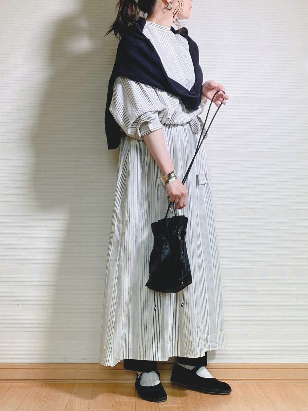 ホワイト系のワンピース、ブラック系のショルダーバッグ、ブラック系のその他パンツを着用したレディースの春コーディネートの1枚目の写真