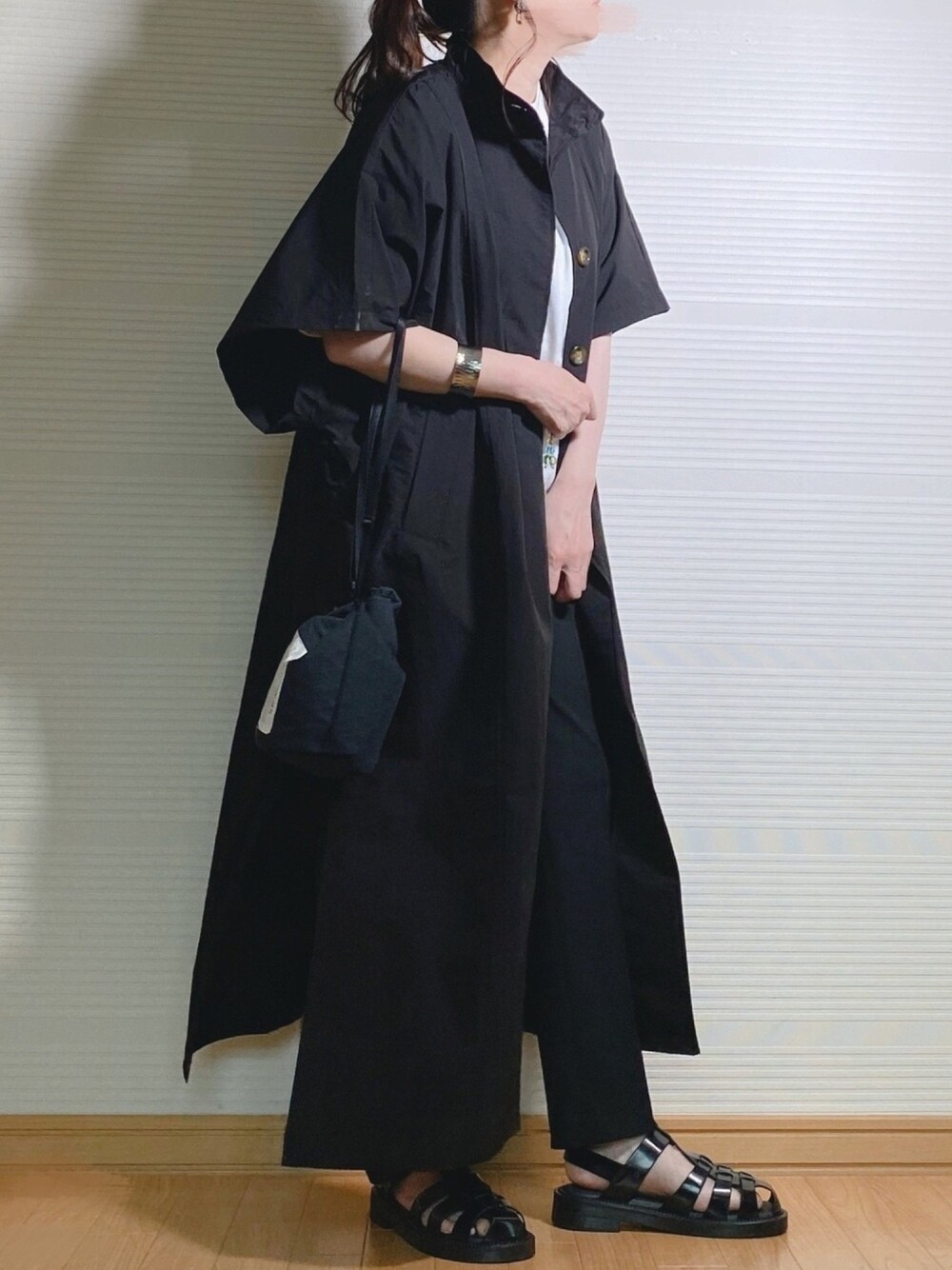 ブラック系のトレンチコート、ブラック系のその他パンツ、ブラック系のボディバッグ/ウエストポーチを着用したレディースの春コーディネートの1枚目の写真