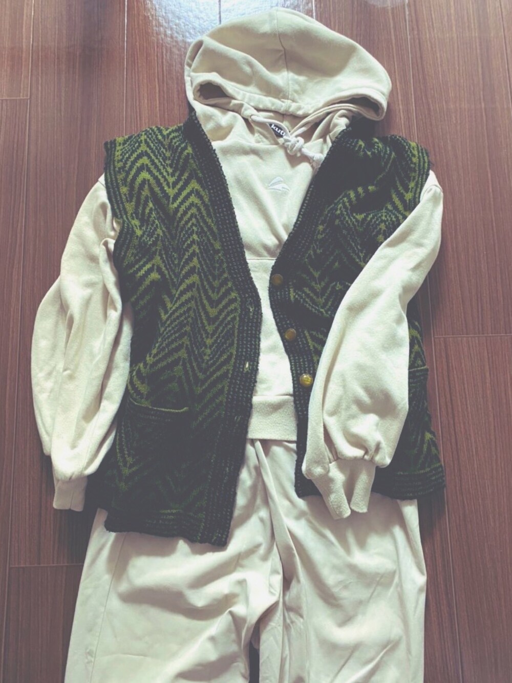 ホワイト系のパーカー、グリーン系のベスト、ホワイト系のパンツを着用したレディースの春コーディネートの1枚目の写真