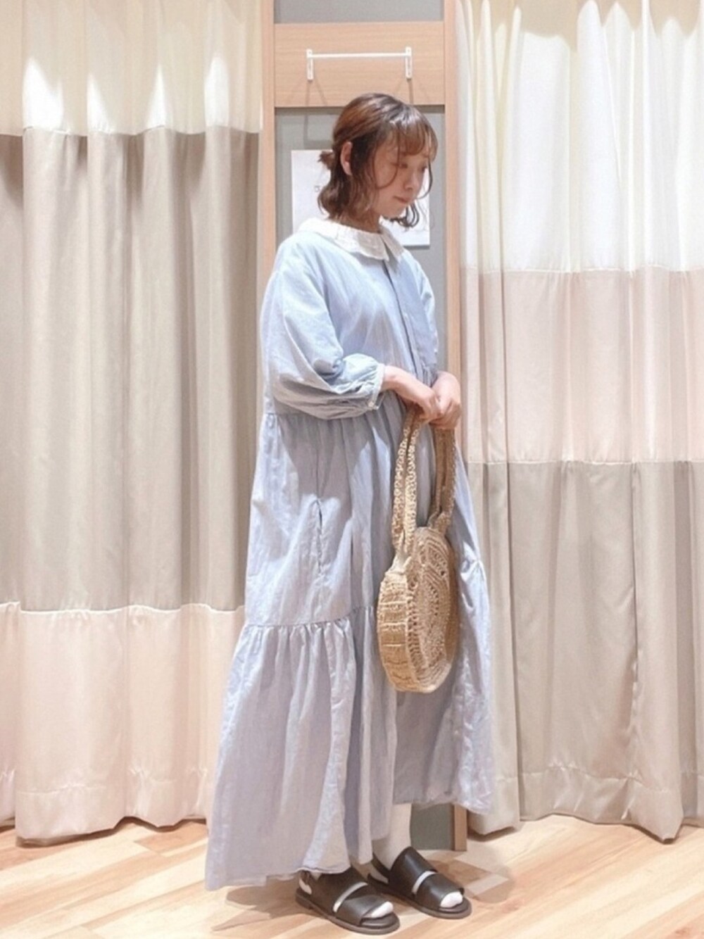 ブルー系のワンピース、ホワイト系のシャツ/ブラウス、ブラウン系のサンダルを着用したレディースの春コーディネートの1枚目の写真