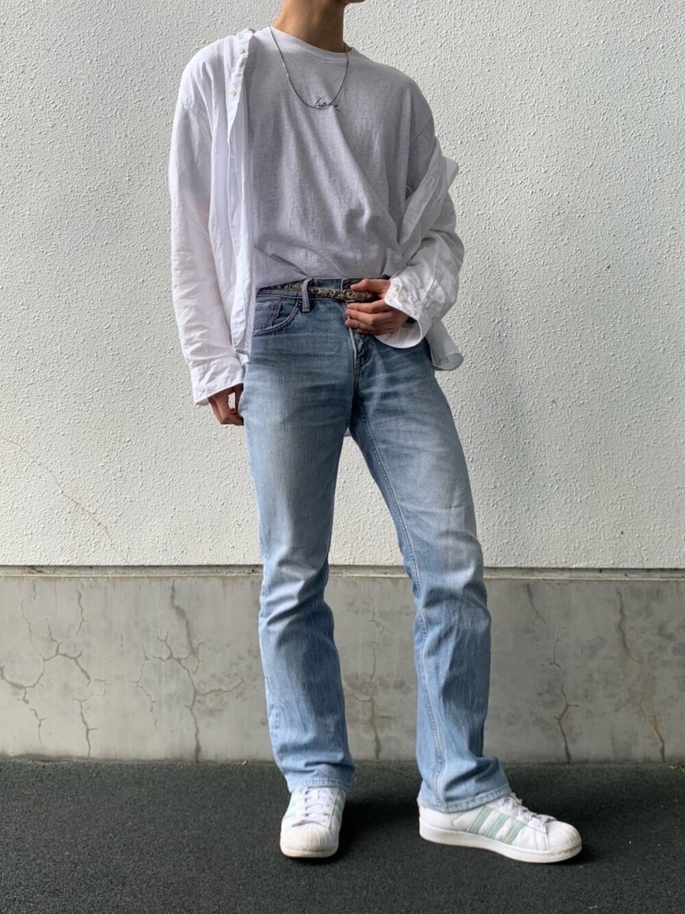 グレー系のデニムパンツ、ホワイト系のTシャツ/カットソー、ホワイト系のシャツ/ブラウスを着用したメンズの秋コーディネートの1枚目の写真