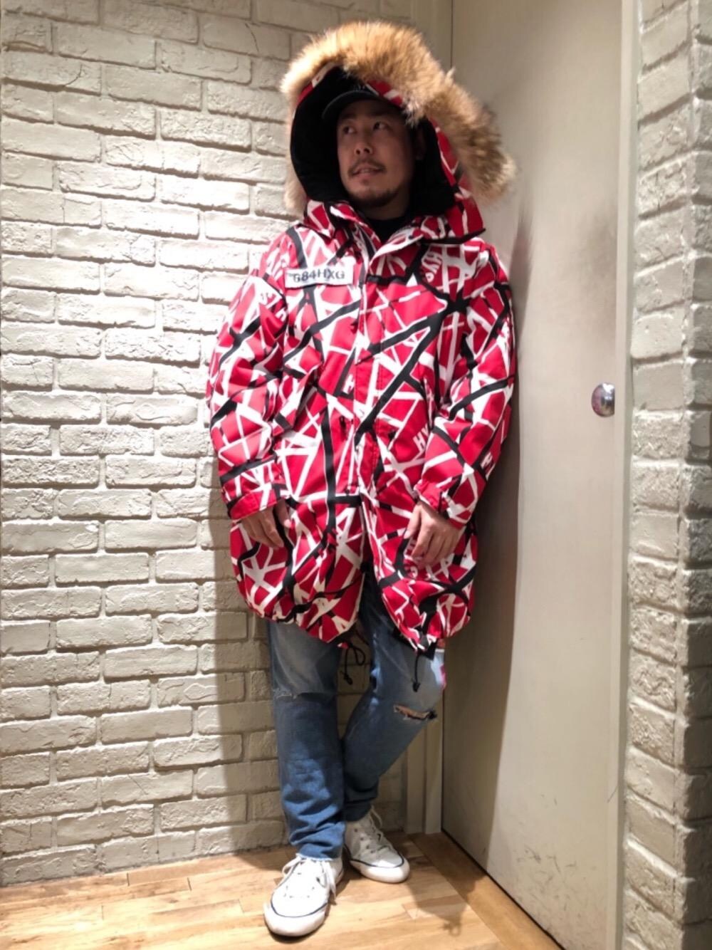 ブルー系のデニムパンツ、レッド系のミリタリージャケット、ブラック系のキャップを着用したメンズの秋コーディネートの1枚目の写真