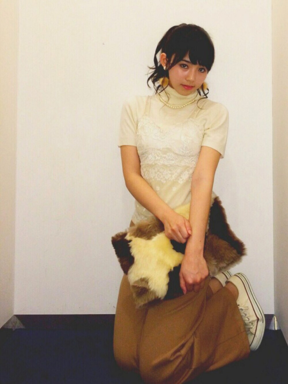 ベージュ系のその他パンツ、ブラウン系のクラッチバッグを着用したレディースの冬コーディネートの1枚目の写真
