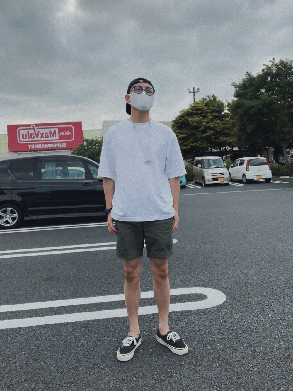 ブラック系のTシャツ/カットソー、グリーン系のパンツ、ブラック系のスニーカーを着用したメンズの春コーディネートの1枚目の写真