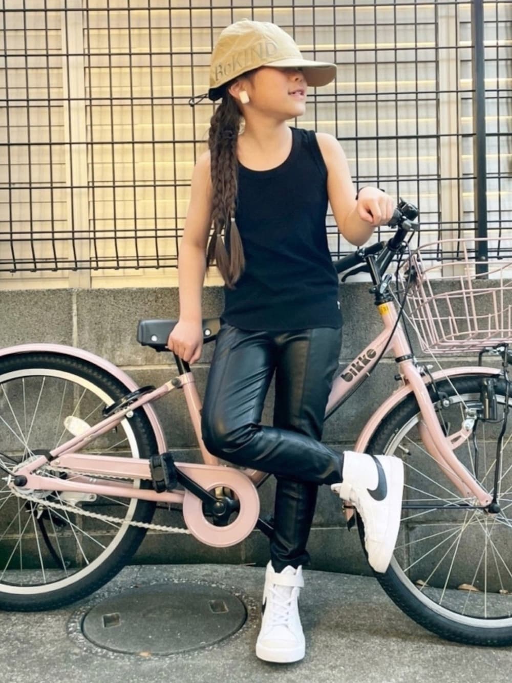 ブラック系のタンクトップ、ホワイト系のスニーカー、ベージュ系のキャップを着用したキッズの春コーディネートの1枚目の写真