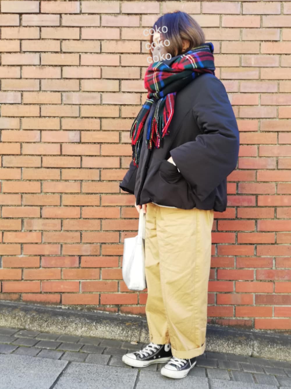 ブラック系のダウンジャケット/コート、ベージュ系のチノパンツ、シルバー系のトートバッグを着用したレディースの冬コーディネートの1枚目の写真