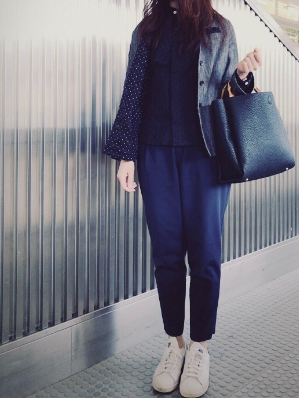 ブラック系のハンドバッグ、ブルー系のその他パンツ、ホワイト系のスニーカーを着用したレディースの春コーディネートの1枚目の写真