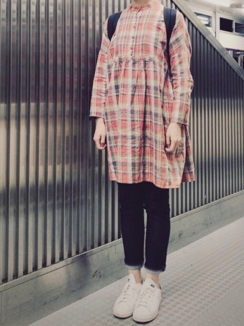 ブルー系のデニムパンツ、ブラック系のバックパック/リュック、ホワイト系のスニーカーを着用したレディースの春コーディネートの1枚目の写真