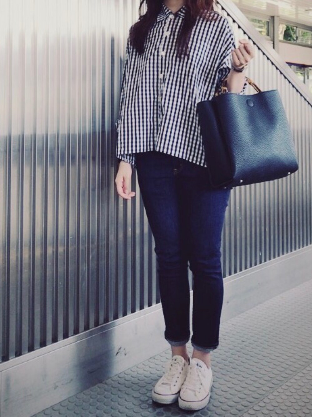 ブラック系のシャツ/ブラウス、ブルー系のデニムパンツ、ブラック系のハンドバッグを着用したレディースの春コーディネートの1枚目の写真