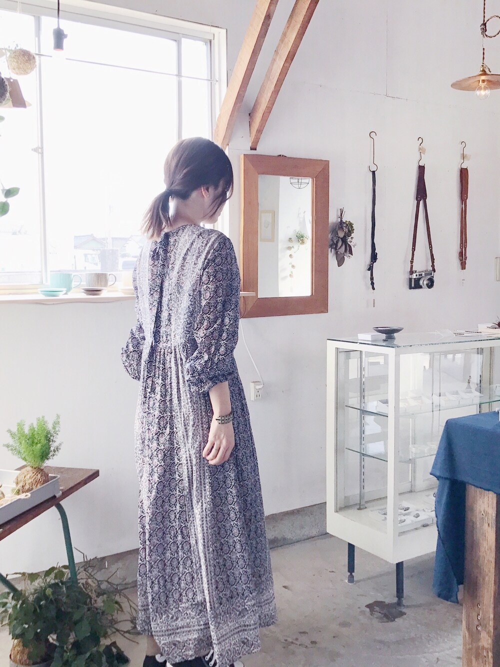ブルー系のワンピース、ブラック系のスニーカー、シルバー系のブレスレットを着用したレディースの秋コーディネートの1枚目の写真