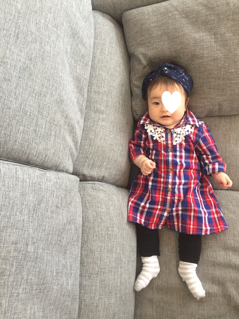 レッド系のシャツワンピース、ブラック系のヘアバンドを着用したキッズの春コーディネートの1枚目の写真