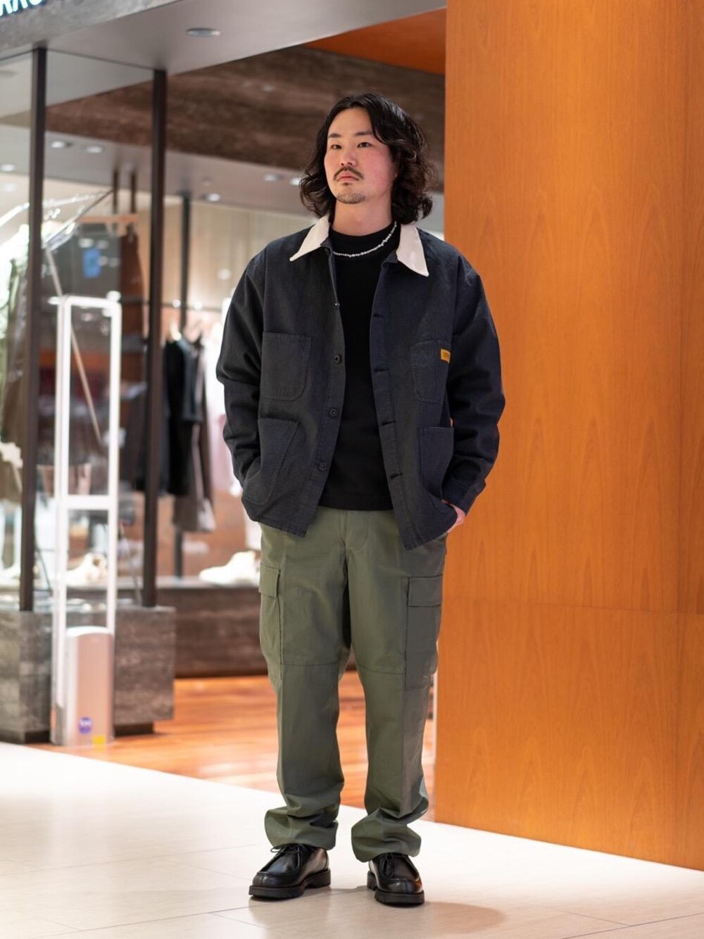 ブラック系のモカシン/デッキシューズ、ブラック系のTシャツ/カットソー、グレー系のカバーオールを着用したメンズの冬コーディネートの1枚目の写真