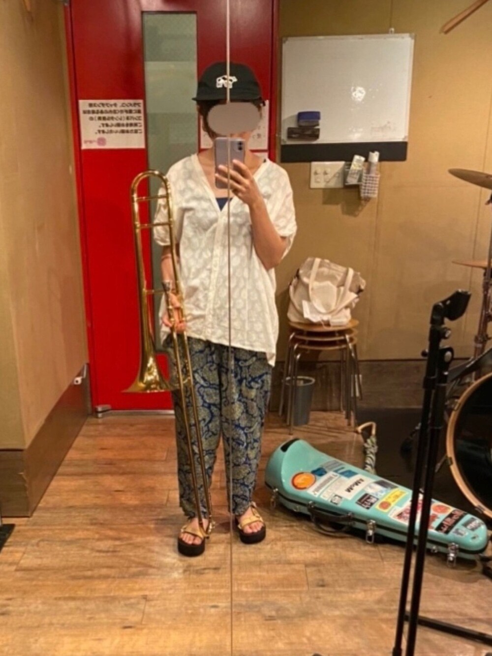 ブルー系のその他パンツ、ゴールド系のサンダル、ブラック系のキャップを着用したレディースの冬コーディネートの1枚目の写真