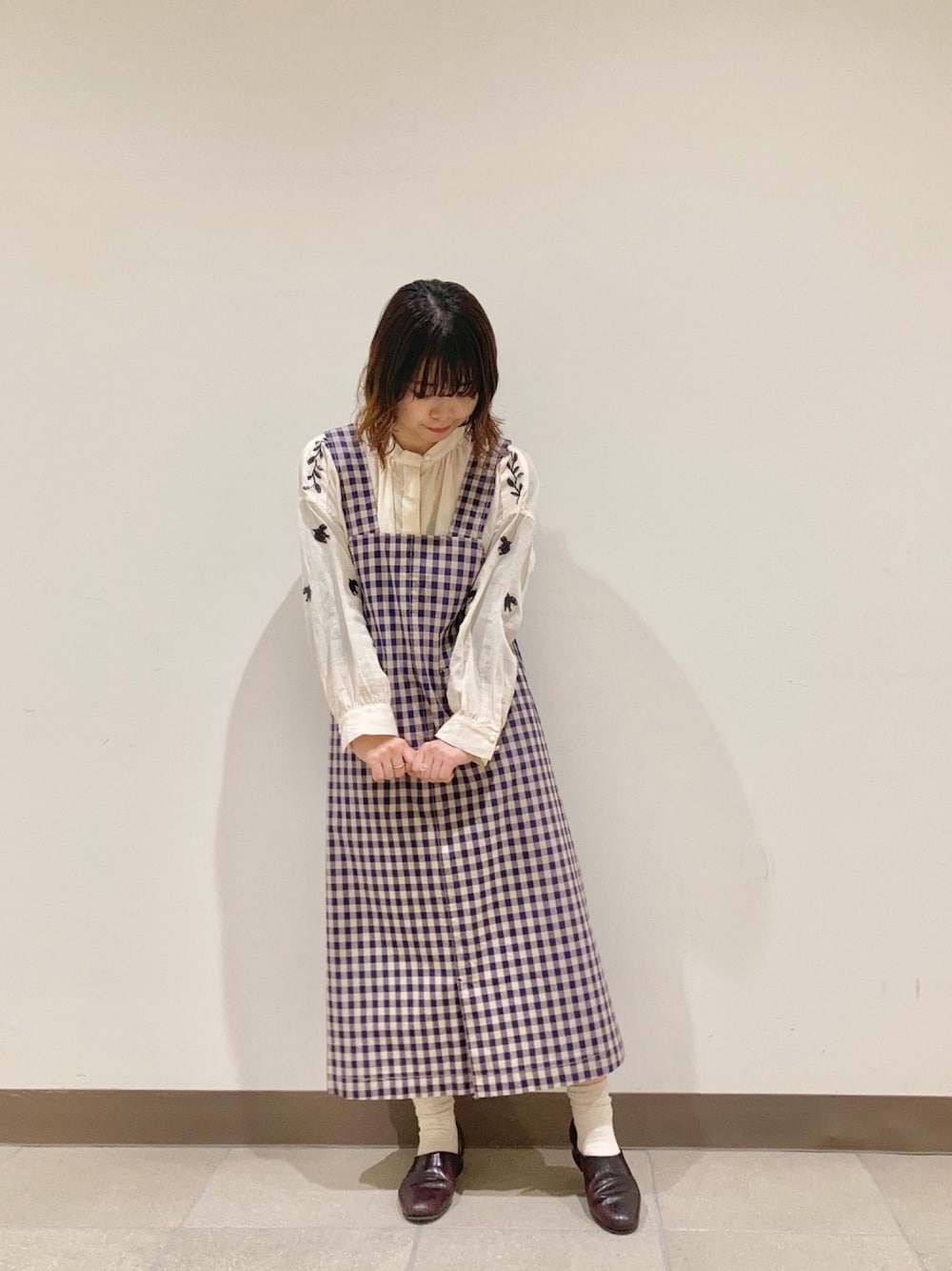 ホワイト系のシャツ/ブラウス、パープル系のジャンパースカートを着用したレディースの春コーディネートの1枚目の写真