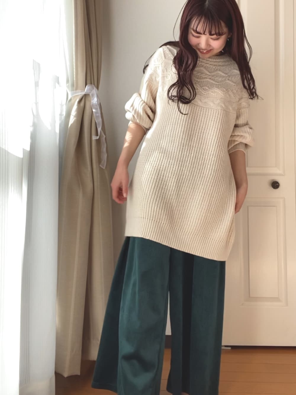 ブルー系のトップス、グリーン系のパンツを着用したレディースの冬コーディネートの1枚目の写真