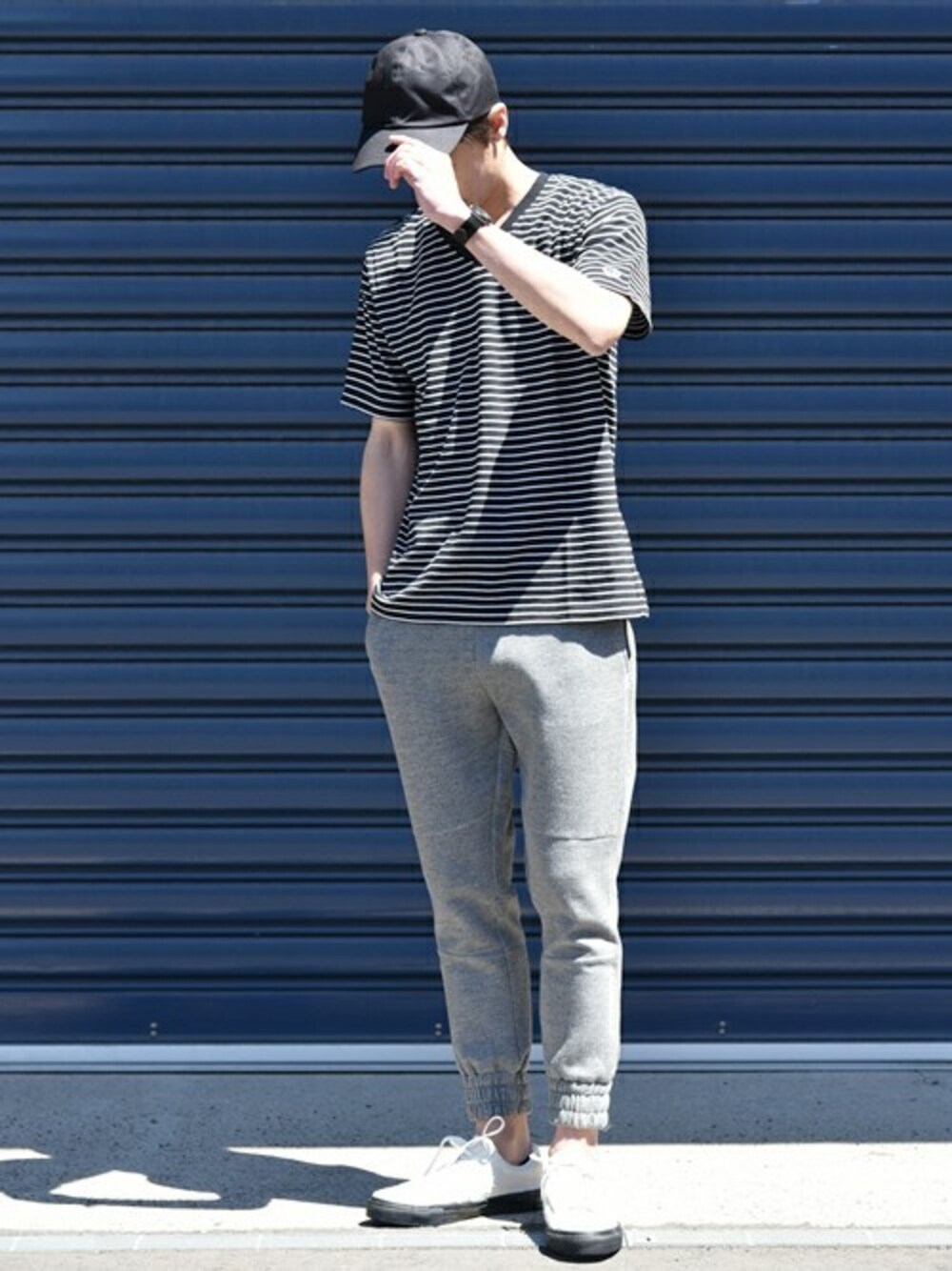 ブラック系のTシャツ/カットソー、グレー系のその他パンツ、ホワイト系のスニーカーを着用したメンズの春コーディネートの1枚目の写真