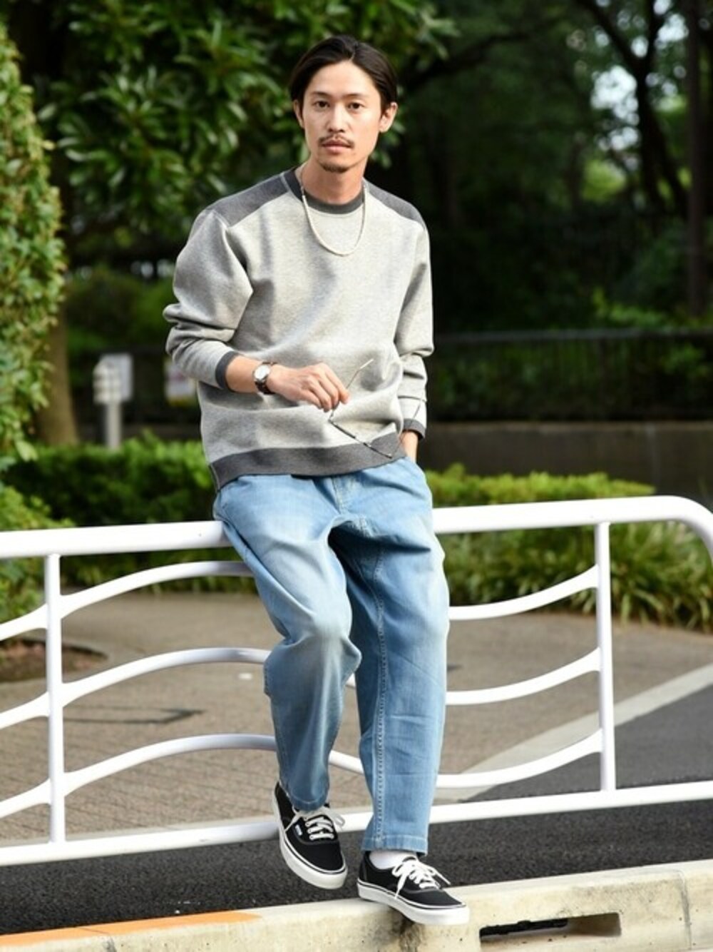 グレー系のTシャツ/カットソー、ブルー系のデニムパンツ、ブラック系のスニーカーを着用したメンズの秋コーディネートの1枚目の写真