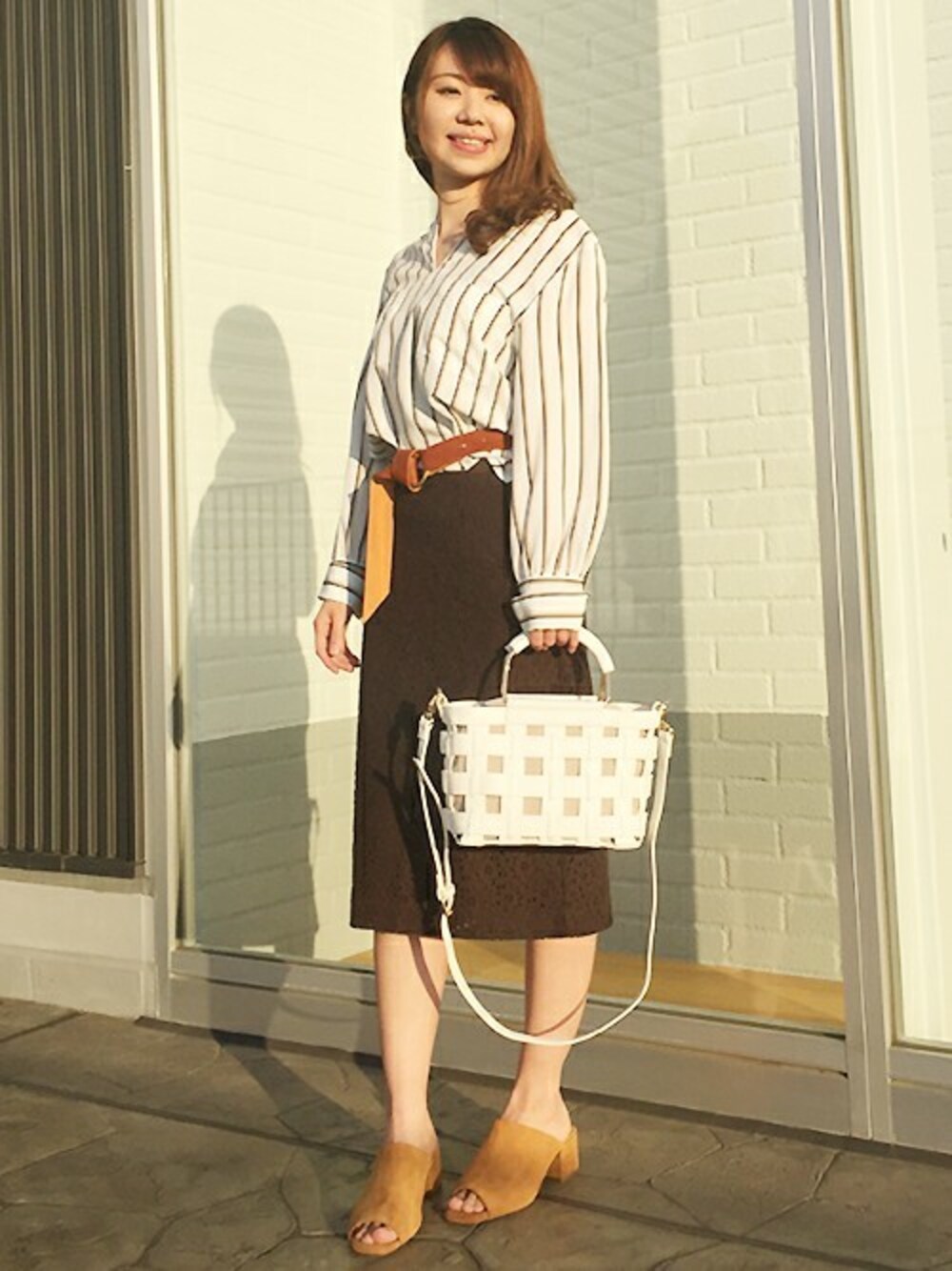 ホワイト系のシャツ/ブラウス、ブラウン系のスカート、ホワイト系のショルダーバッグを着用したレディースの冬コーディネートの1枚目の写真