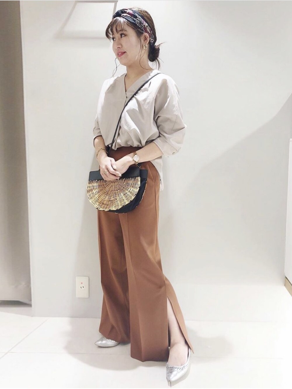 ベージュ系のシャツ/ブラウス、シルバー系のパンプス、ブラウン系のショルダーバッグを着用したレディースの春コーディネートの1枚目の写真