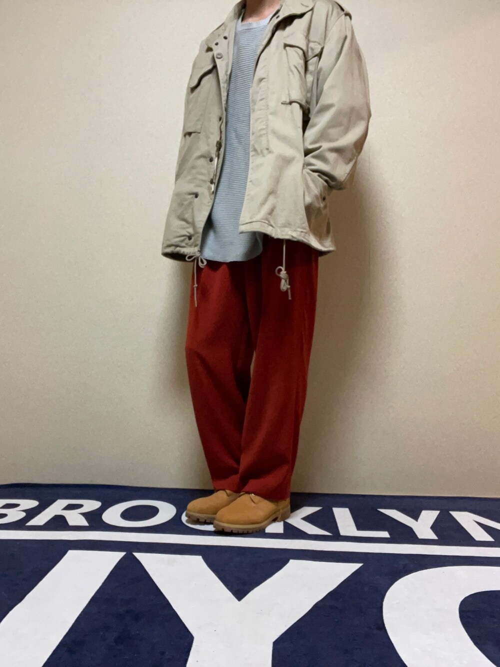 グレー系のニット/セーター、レッド系のその他パンツ、ブラウン系のブーツを着用したメンズの冬コーディネートの1枚目の写真