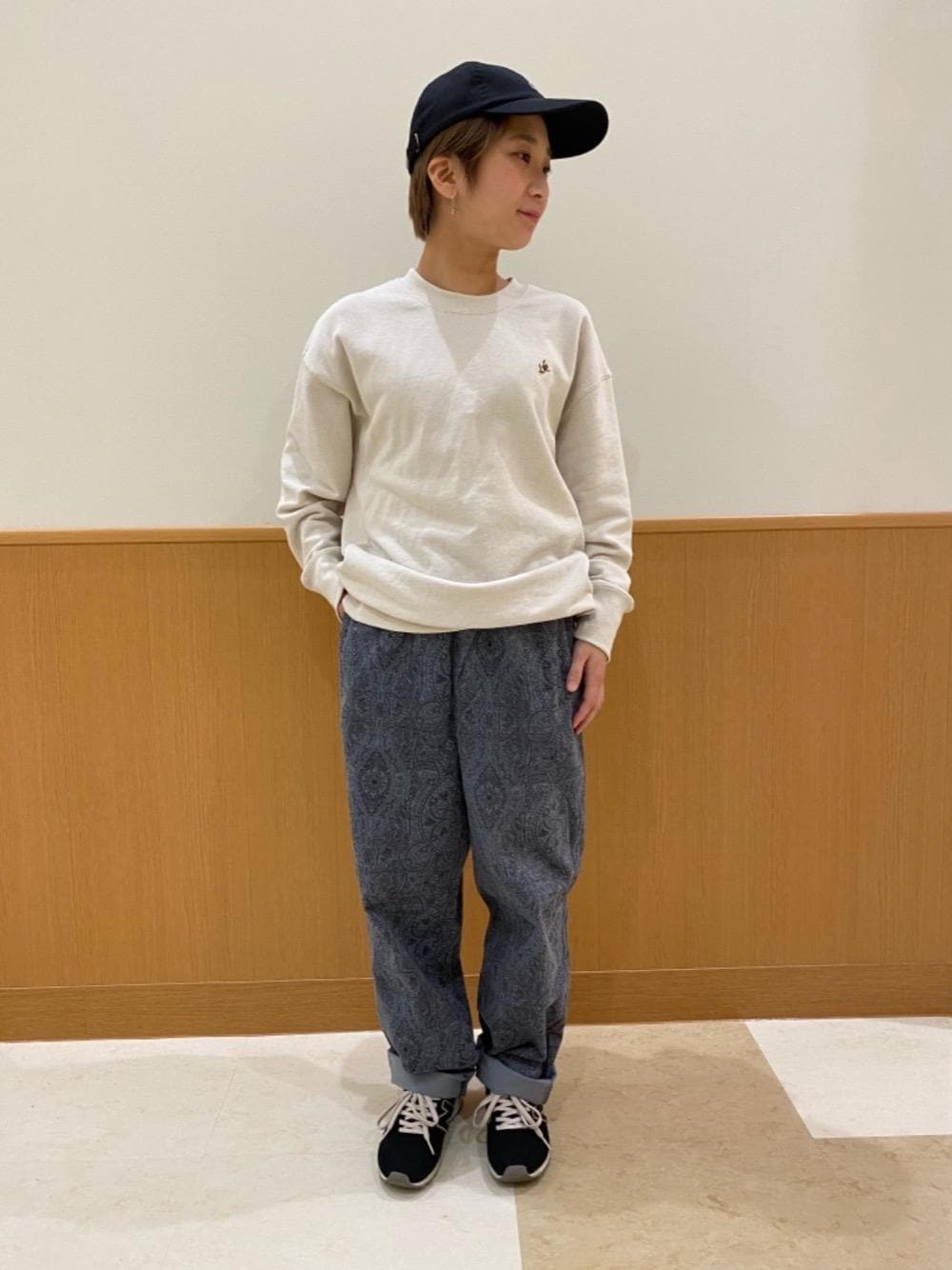 ベージュ系のスウェット、ブルー系のその他パンツ、ブラック系のキャップを着用したレディースの秋コーディネートの1枚目の写真