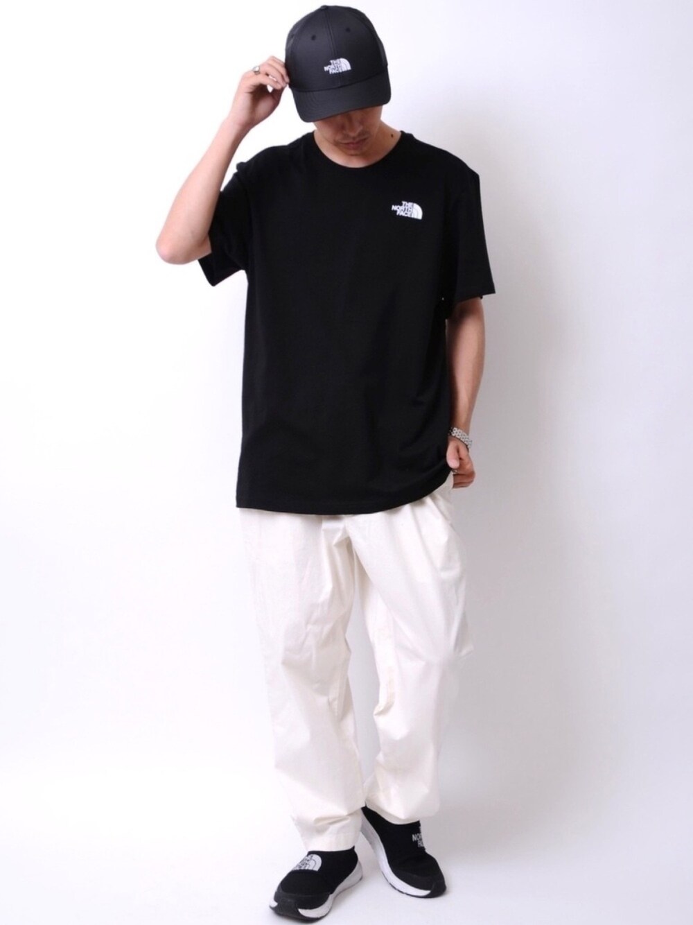 ホワイト系のTシャツ/カットソー、ホワイト系のデニムパンツ、ブラック系のスニーカーを着用したメンズの春コーディネートの1枚目の写真