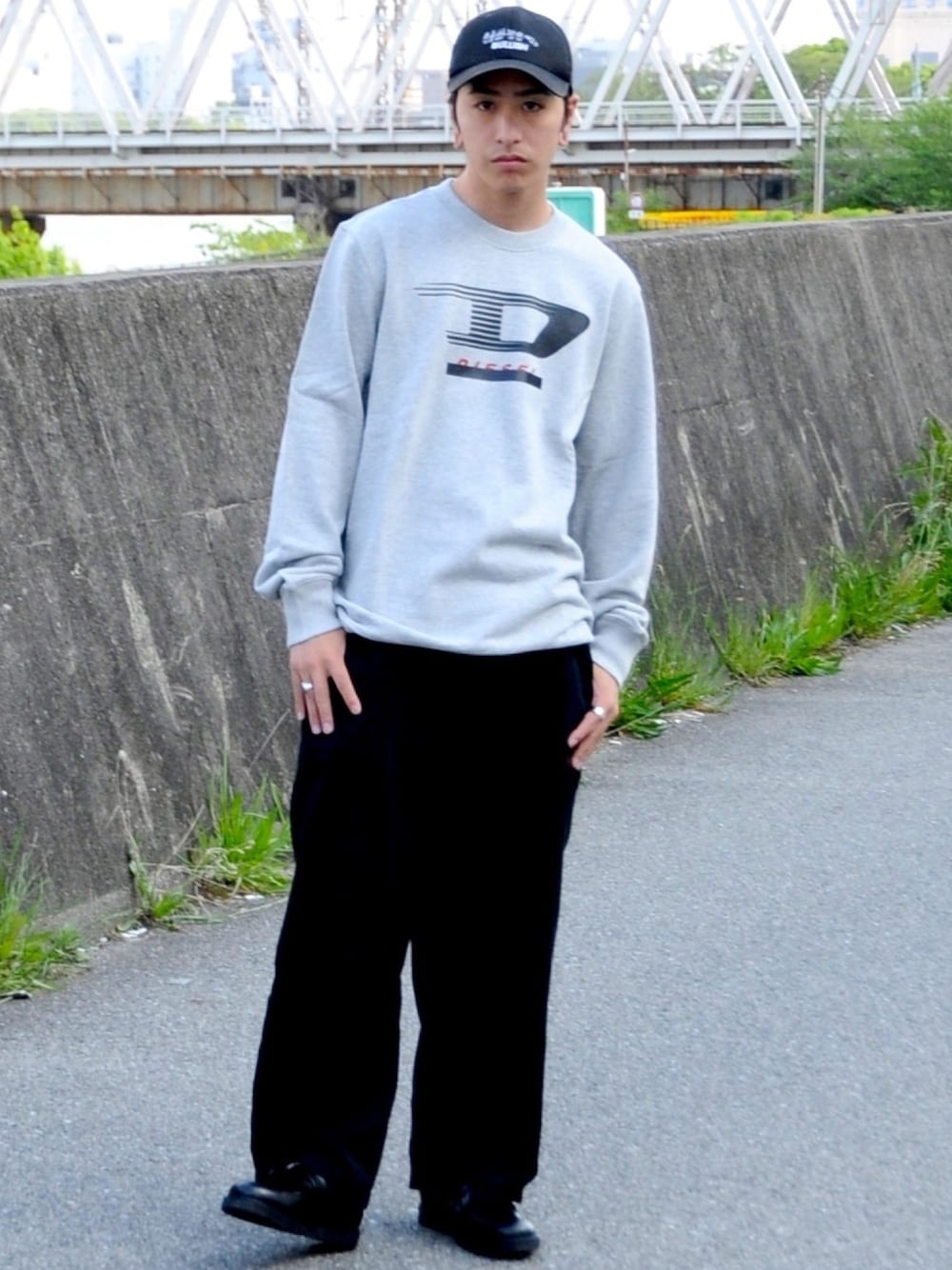 ブラック系のスウェット、ブラック系のデニムパンツ、ブラック系のローファーを着用したメンズの春コーディネートの1枚目の写真