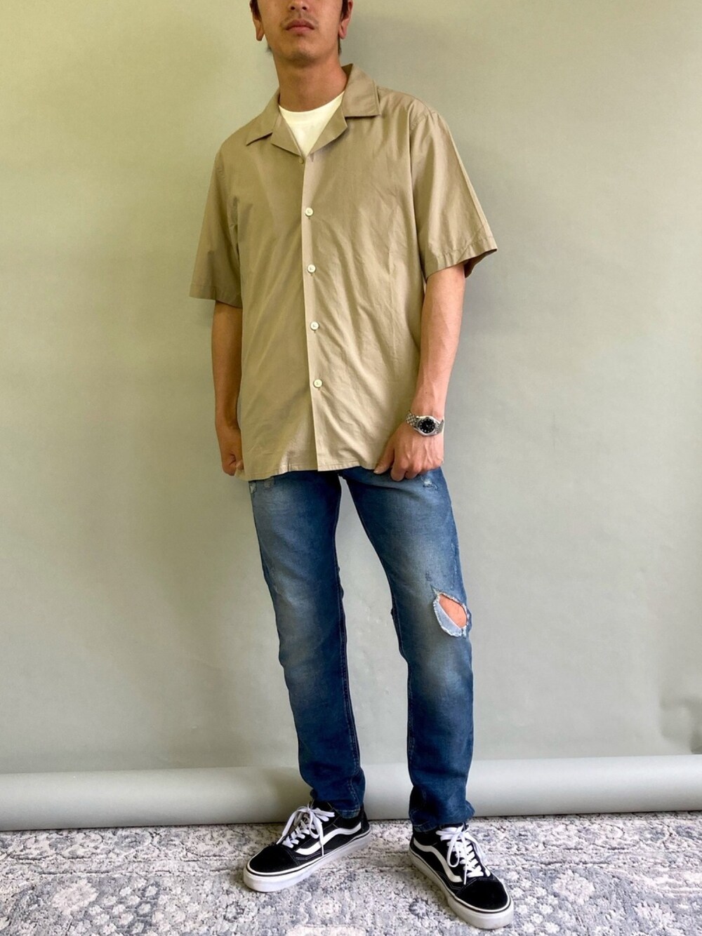 ブルー系のデニムパンツ、ベージュ系のシャツ/ブラウス、ブラック系のスニーカーを着用したメンズの春コーディネートの1枚目の写真