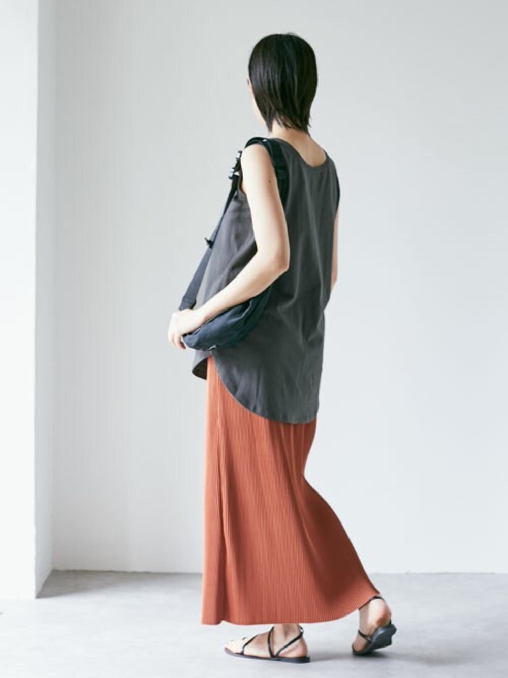 グレー系のタンクトップ、オレンジ系のスカート、ブラック系のサンダルを着用したレディースの夏コーディネートの1枚目の写真