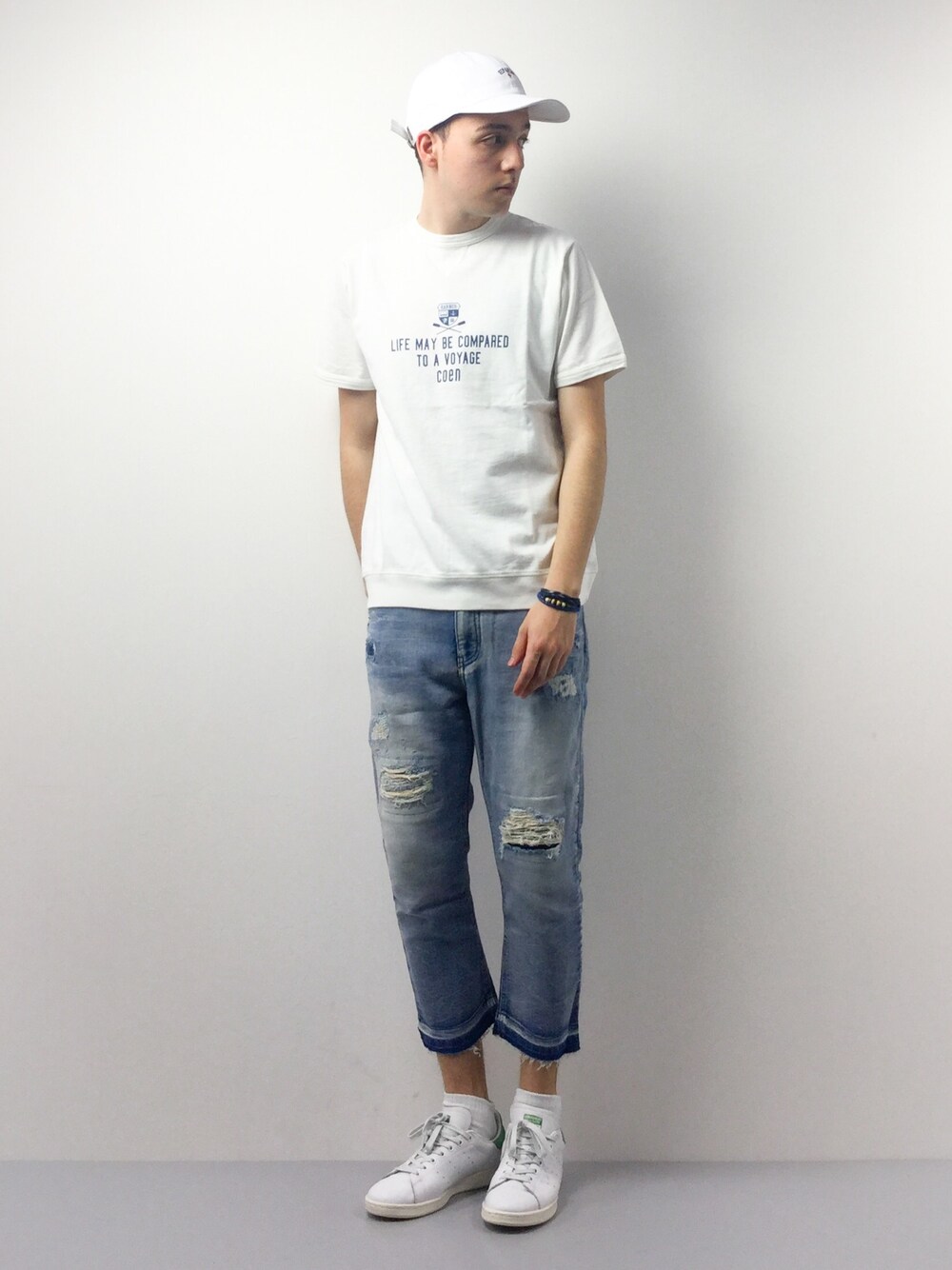 ホワイト系のTシャツ/カットソー、ブルー系のデニムパンツ、ホワイト系のキャップを着用したメンズの春コーディネートの1枚目の写真