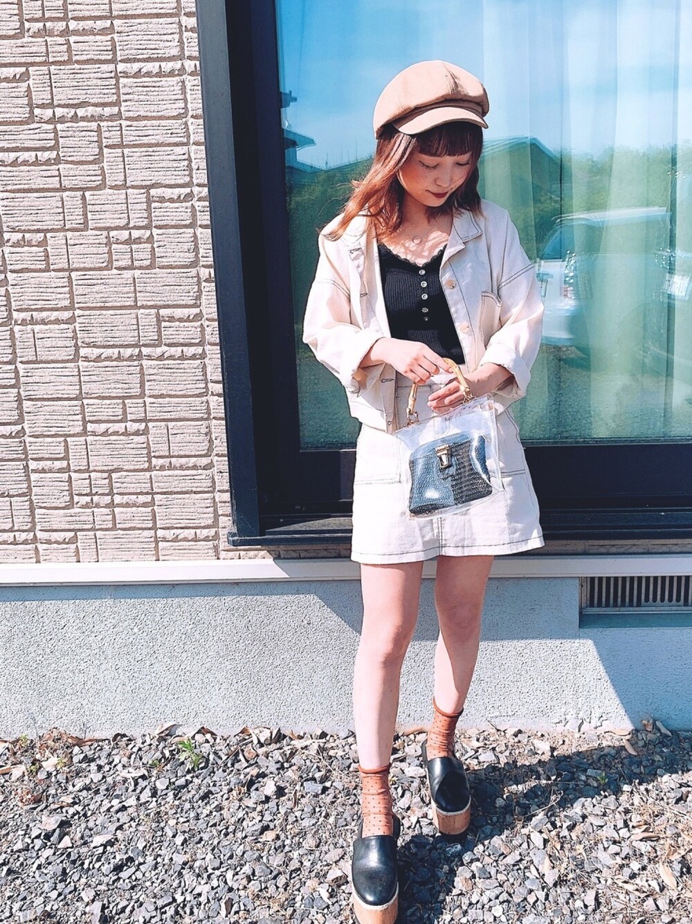 ブラック系のキャミソール、ホワイト系のスカート、ブラック系のハンドバッグを着用したレディースの春コーディネートの1枚目の写真