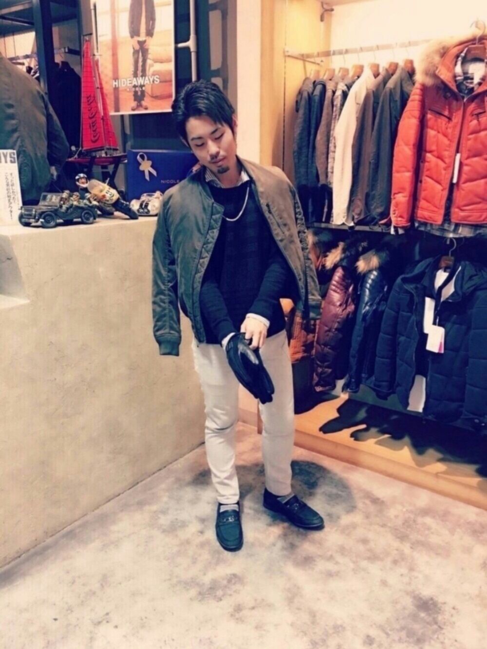 ブルー系のニット/セーター、グリーン系のMA-1、ブラック系の手袋を着用したメンズの冬コーディネートの1枚目の写真