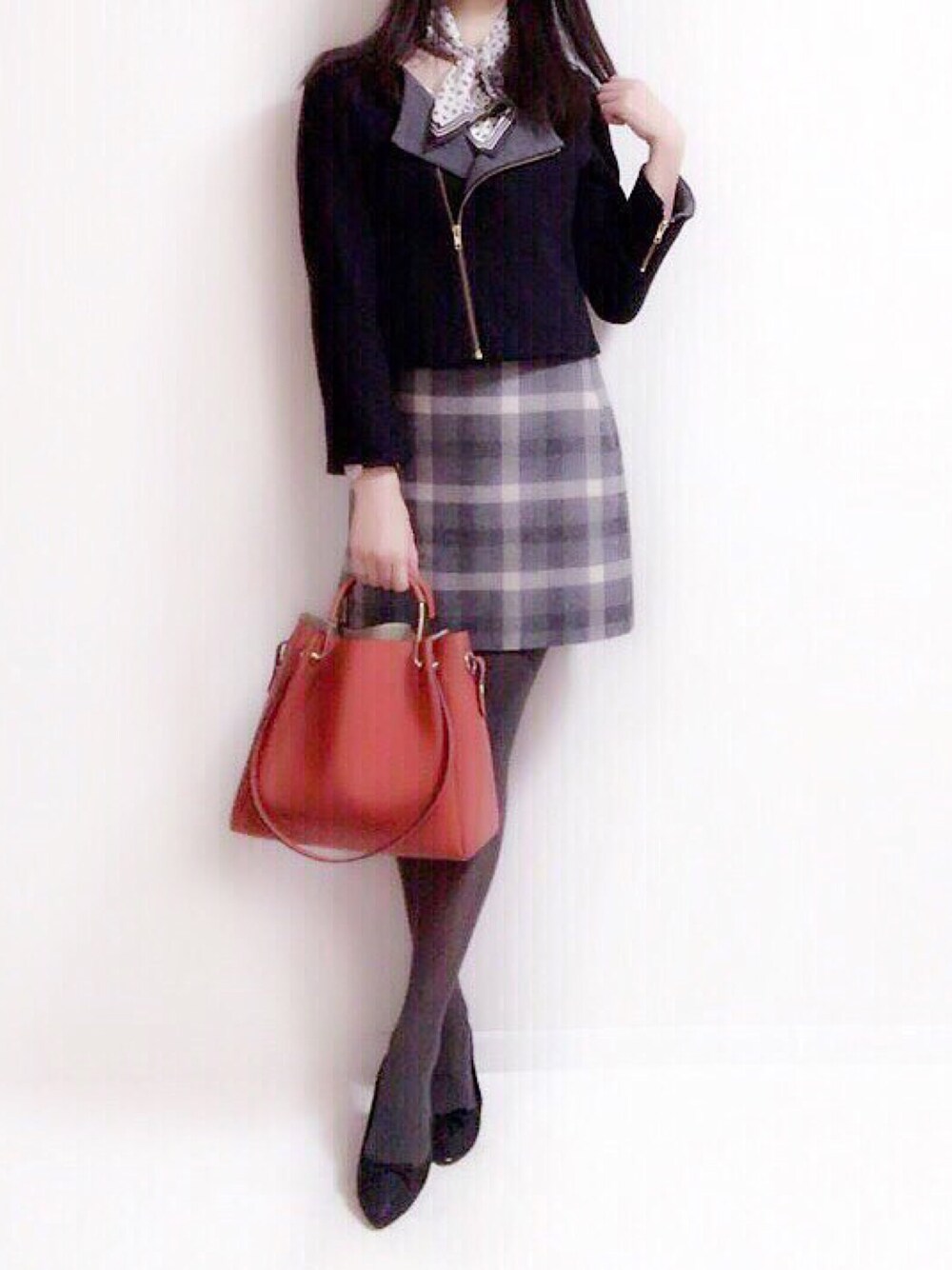 グレー系のスカートを着用したレディースの秋コーディネートの1枚目の写真