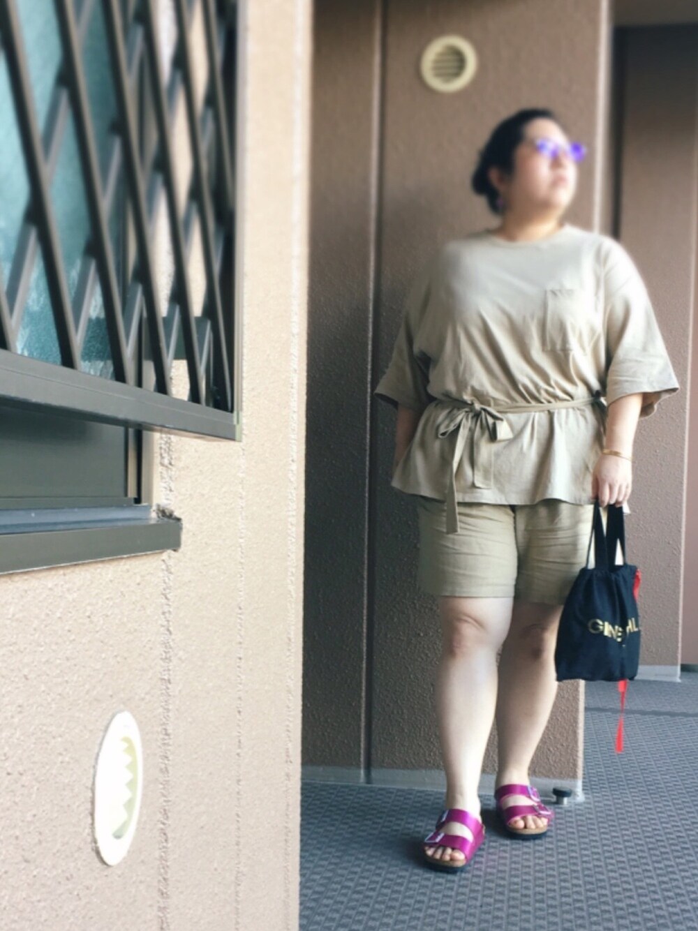 ベージュ系のTシャツ/カットソー、ベージュ系のパンツ、ブラック系のトートバッグを着用したレディースの冬コーディネートの1枚目の写真