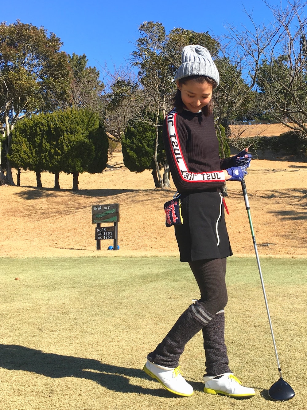 ブラック系のニット/セーター、ブラック系のスカート、イエロー系のバッグを着用したレディースの冬コーディネートの1枚目の写真