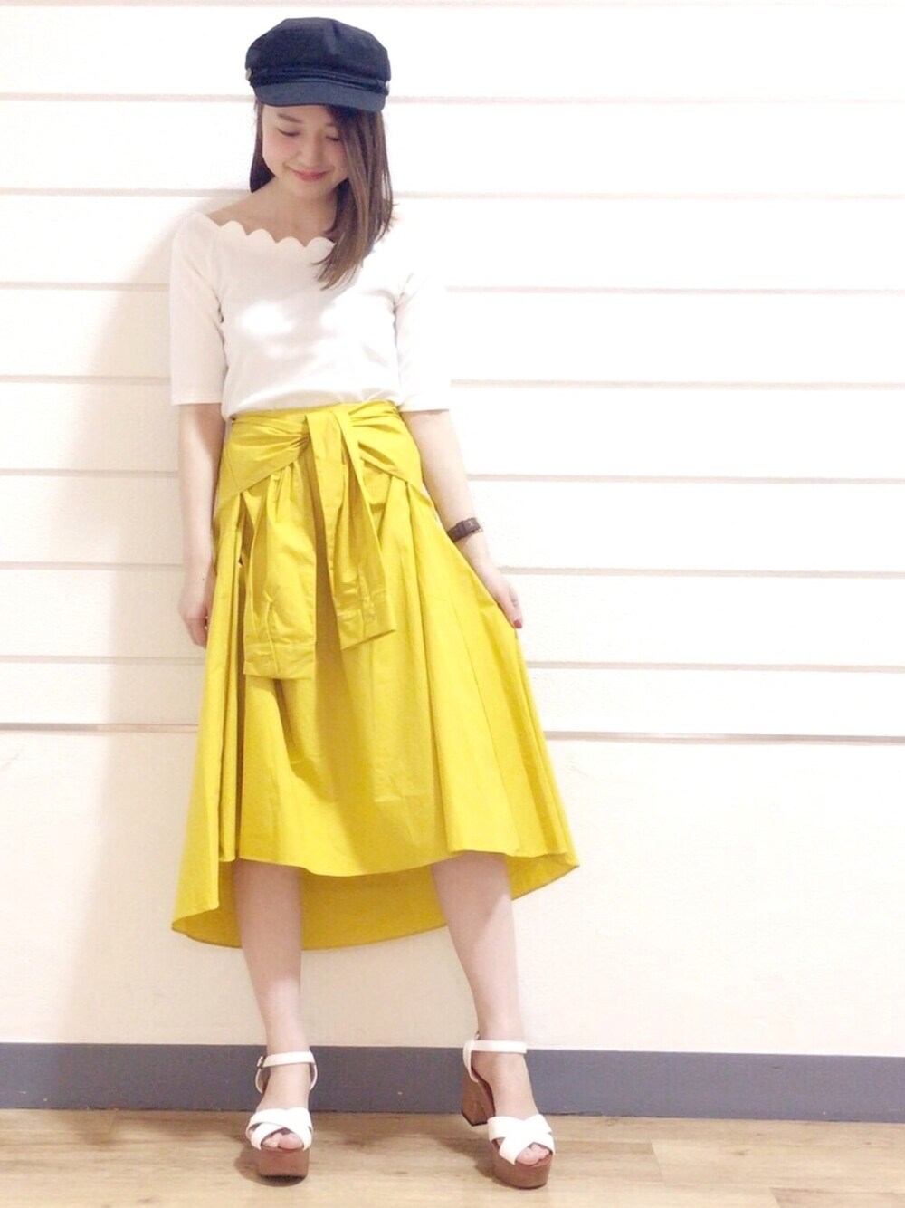 ホワイト系のTシャツ/カットソー、イエロー系のスカート、ホワイト系のサンダルを着用したレディースの春コーディネートの1枚目の写真