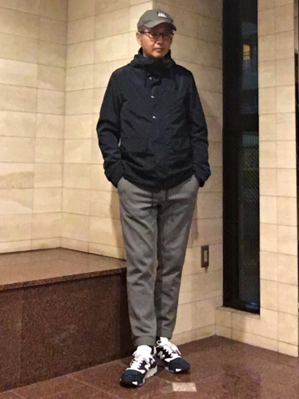 ブルー系のナイロンジャケット、グレー系のその他パンツ、ブルー系のスニーカーを着用したメンズの春コーディネートの1枚目の写真