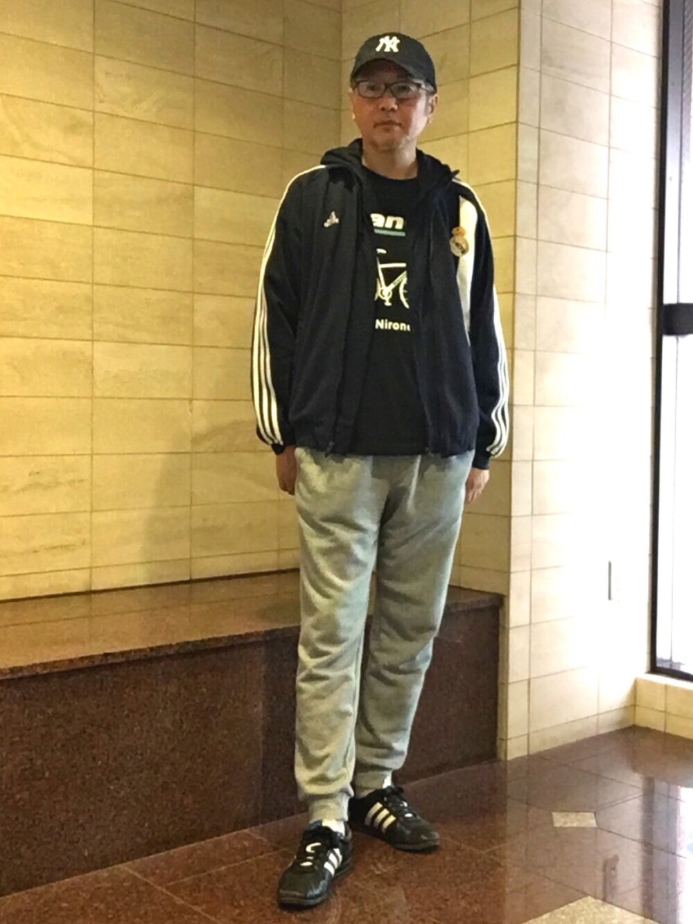 ブルー系のジャージ、ブラック系のTシャツ/カットソー、ホワイト系のパンツを着用したメンズの春コーディネートの1枚目の写真