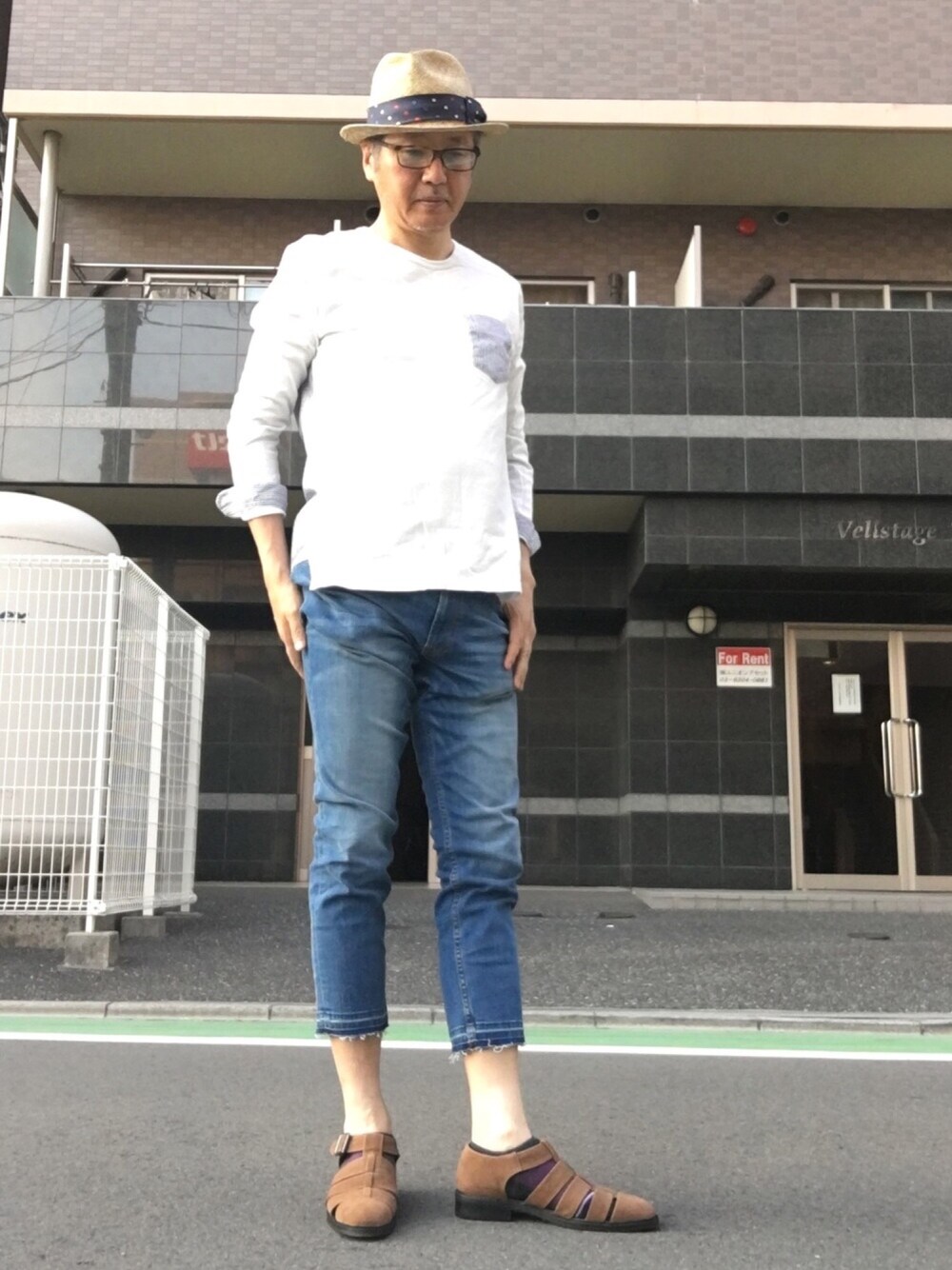 ホワイト系のTシャツ/カットソー、ブルー系のデニムパンツ、ブラウン系のサンダルを着用したメンズの夏コーディネートの1枚目の写真